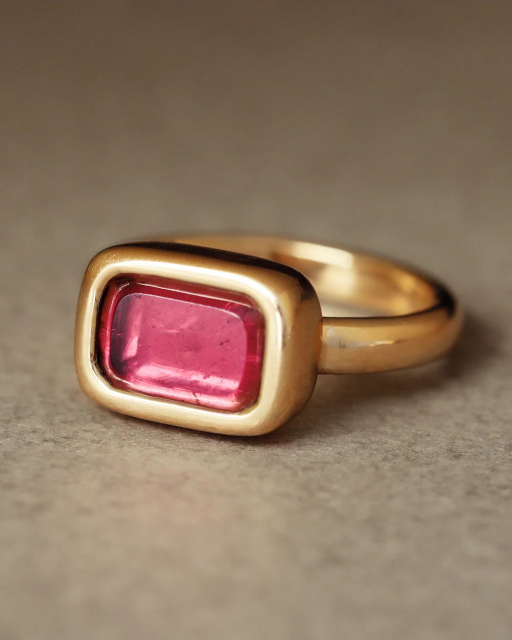 a gold ring with a pink stone